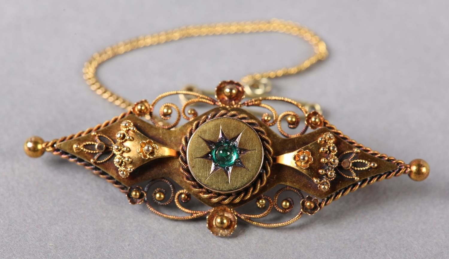 AN EDWARD VII DEMANTOID GARNET BAR BROOCH in 15ct gold, the cabochon cut stone star set to the