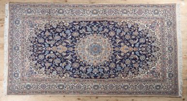 A MIDDLE EASTERN CARPET, Persian, having a blue field filled with flowering tendrils and central