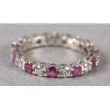 A RUBY AND DIAMOND ETERNITY RING BY TIFFANY AND CO in platinum, the circular faceted rubies and