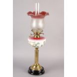 A VICTORIAN BRASS OIL LAMP, the pink tinted glass reservoir painted with Gaelic harp and shamrock,