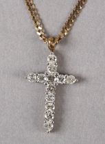 A DIAMOND SET CROSS in 9ct gold, the brilliant cut stones claw set, hung from a faceted curb link