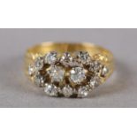 A VICTORIAN DIAMOND CLUSTER RING in 18ct gold, the old European cut stones claw set within a pierced