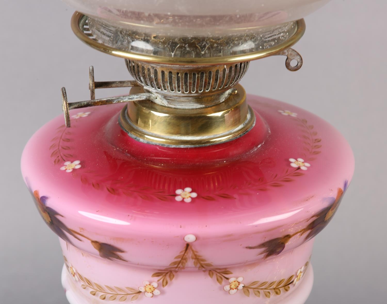 A NEAR PAIR OF VICTORIAN BRASS OIL LAMPS, the pink tinted reservoirs painted with mauve flower heads - Image 5 of 5