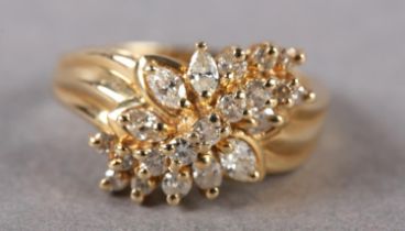 A DIAMOND CLUSTER RING, the brilliant and marquise cut stones claw set in a leaf shaped outline
