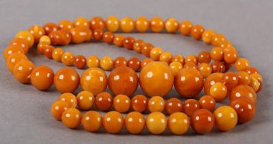 AN EARLY 20TH CENTURY AMBER NECKLACE of graduated spherical beads, approximate maximum diameter