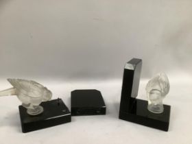 A pair of art-deco book ends mounted with opaque glass birds on polished black glass in the style of