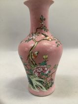 A Chinese famille rose vase decorated with flowering peonies and birds on a graffito pink ground