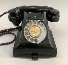 A black GPO bakelite desk telephone with directory tray