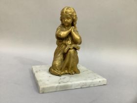 A Victorian gilt metal figure of a young girl kneeling in prayer on an associated marble base, 21.