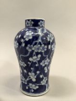 A Chinese blue and white baluster vase, painted with flowering prunus, bearing four character Kangxi