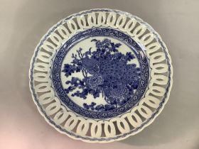A Chinese blue and white charger, the centre containing a peacock in flowering branches within a
