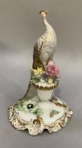 A Royal Crown Derby figure of a peacock perched on a flower filled vase and shaped base, in original