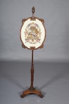 A late regency rosewood pole screen with oval banner in moulded and scrolled frame, the pole with