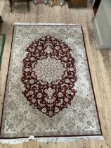 A Turkish wool on cotton hand woven Durude rug, the wine field having an ivory rosette medallion and