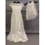A 1950's cream machine lace wedding dress, the design floral, the neck scalloped, with short