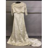 A 1960’s cream wedding dress, slim-line, fitted machine lace bodice integral to the rear and loose