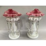 A pair of 19th century cranberry and white table lustres, with handkerchief rims overpainted with