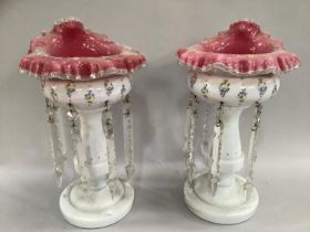 A pair of 19th century cranberry and white table lustres, with handkerchief rims overpainted with