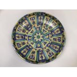 A large 20th century North African earthenware charger painted in blues and greens on foot, 39.5cm