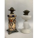 A 19th century ceramic oil lamp in the Imari taste, with metal mounts together with a milk glass oil