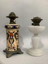 A 19th century ceramic oil lamp in the Imari taste, with metal mounts together with a milk glass oil