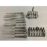 Two early to mid 20th. Century silver plated toast racks together with eleven silver barrelled tea
