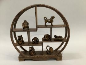 Four boxwood netsuke figures carved as a dog, a monkey catching a fish, a dragon and a sumo wrestler