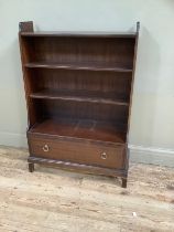 Stag bookcase with three shelves over one long drawer with brass handles, carved apron on square