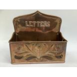 Keswick school style copper letter rack, with plannished and pierced decoration and relief moulded