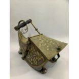 A 19th century brass coal scuttle of sleigh form, the side panels embossed with fruiting vine,