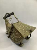 A 19th century brass coal scuttle of sleigh form, the side panels embossed with fruiting vine,