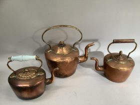 Three 19th century copper kettles of varying sizes including one with glass handle