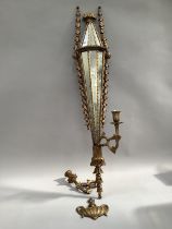 A gilt wood girandole with twin sconces, having panelled mirror back, with foliate beading and