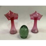 A pair of flared fluted slender neck cranberry vases with flared rims, 20cm high together with a