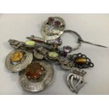 A small collection of 19th. and 20th. century Scottish brooches variously set with amethyst, tiger