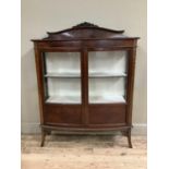 An Edwardian mahogany double bow fronted cabinet with glazed doors over three internal shelves,