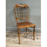 A fruitwood bobbin backed bedroom chair with caned seat and turned legs