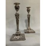 A pair of George IV style silver plate on copper candlesticks, moulded in high relief with urn