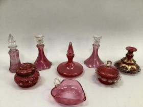 Pair of cranberry glass candle sticks and a matching scent bottle, another scent bottle, gilt candle