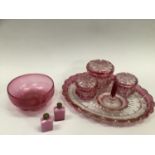 A bohemian cranberry cut glass trio of lidded dishes with hobnail sections together with a tray,
