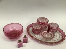 A bohemian cranberry cut glass trio of lidded dishes with hobnail sections together with a tray,