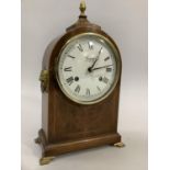 A 20th century walnut mantle clock by Comitti of London, the enamel dial with Roman numerals, in