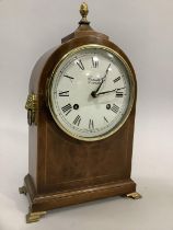 A 20th century walnut mantle clock by Comitti of London, the enamel dial with Roman numerals, in