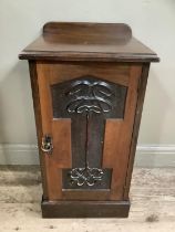 An Art Nouveau style walnut pot cupboard with carved front panel on plinth base, 45cm x 40cm