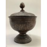 A patinated bronzed Greek style urn and cover with acorn finial, the fluted body on moulded foot,