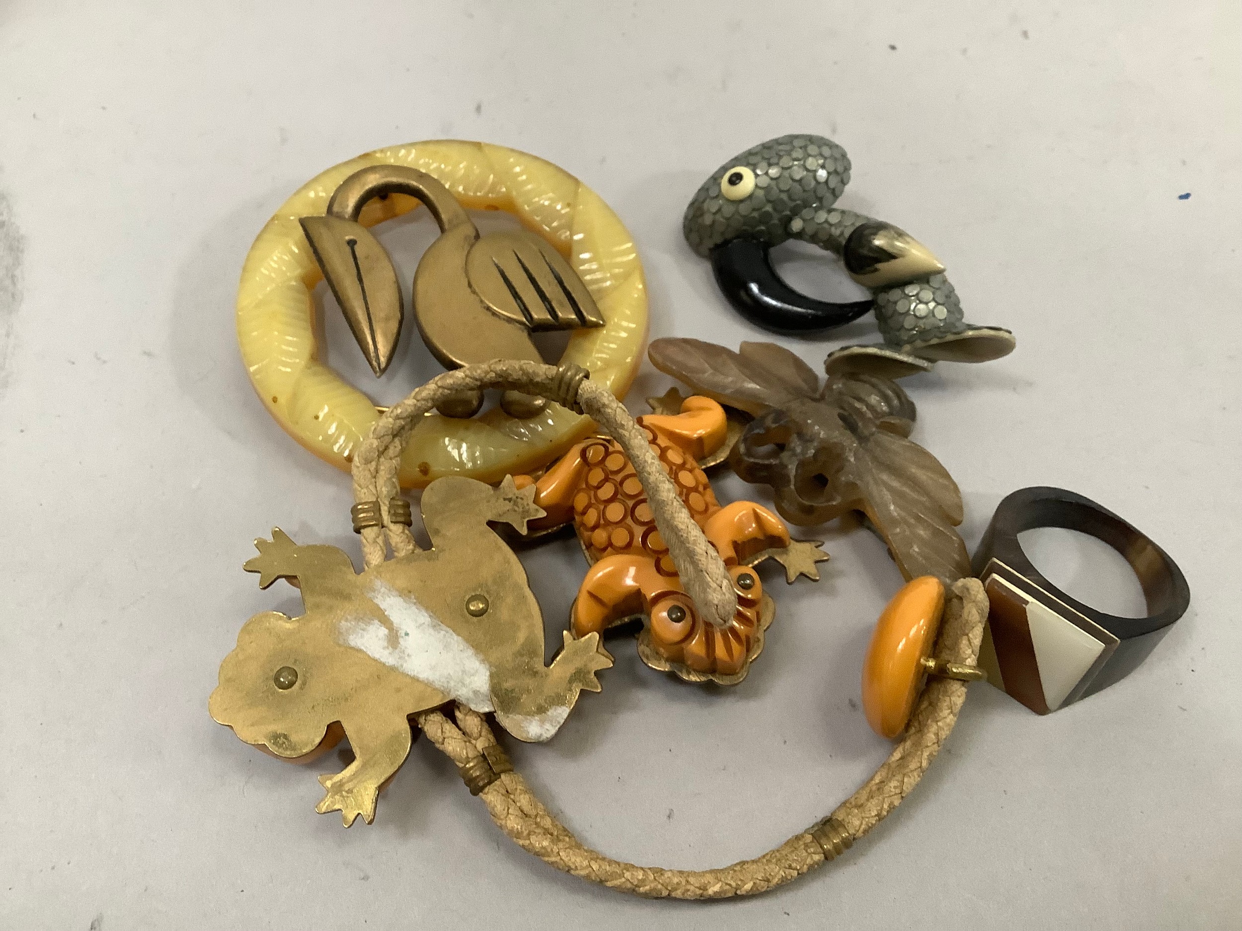 An early 20th. century frog brooch and bracket suite in base metal, textile and composite together