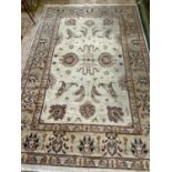 Pakistani hand knotted woolen rug, the ivory field filled with opposing floral motifs within