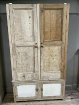 A pine early 20th century kitchen cupboard with two doors above two smaller doors on square feet,