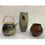 Three items of Peter Sparrey studio pottery comprising, a burnt umber ovoid vase, tall vase with