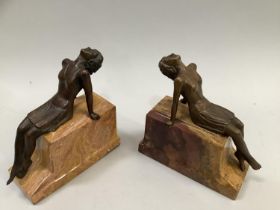 Art Deco style bookends of bronzed female reclining figures on ochre marble stepped plinth, 17cm